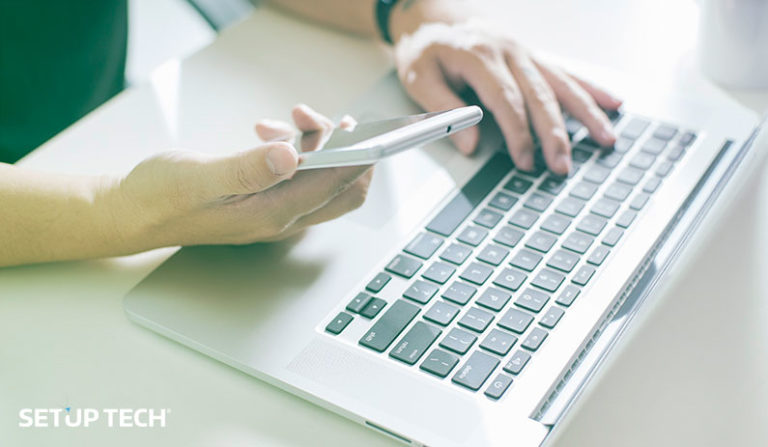 Homem a utilizar telemóvel com computador como fundo - Post: Competitividade entre empresas: criar app Android