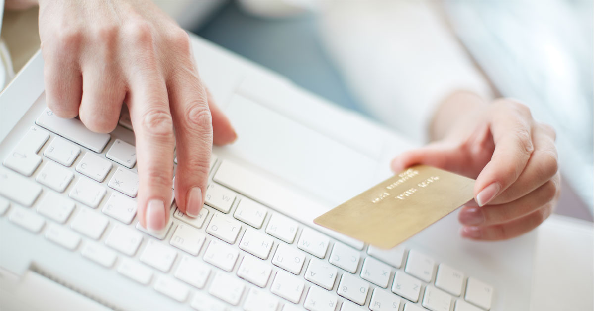 Mulher a usar um cartão de crédito e um computador (e-commerce)